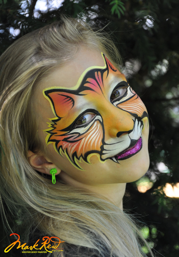 young blonde girl face painted with a tiger face